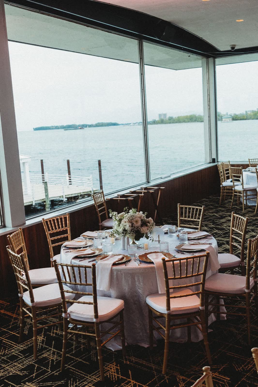 Room dressed for an evening event with the Detroit River beyond