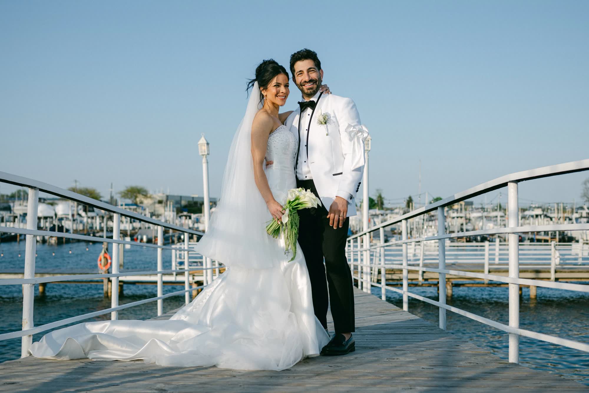 Couple on the dock at golden hour with the Detroit River behind them